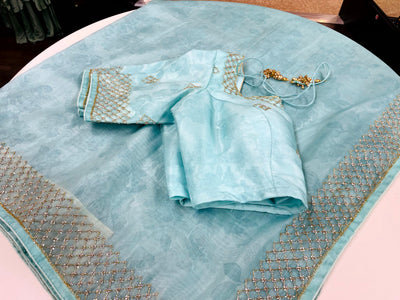 LIGHT BLUE COLORED ORGANZA SAREE WITH SELF COLORED FLORAL PRINTS AND A MATCHING BLOUSE