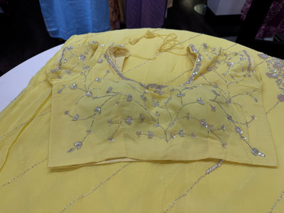 Pastel yellow embroidered georgette saree with stitched blouse